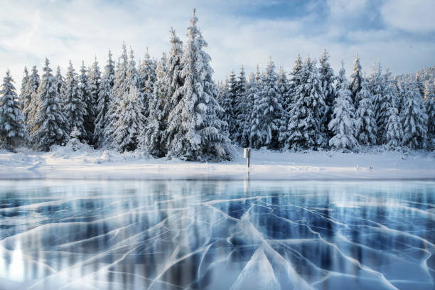 istock Blue ice and cracks on the surface of the . 645351050
