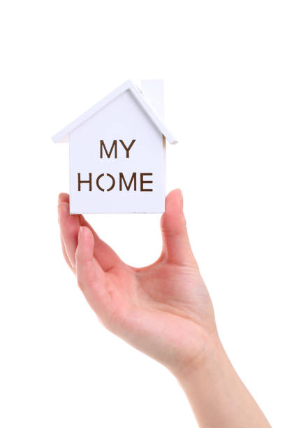 istock Hand holding miniature model of house 645370542