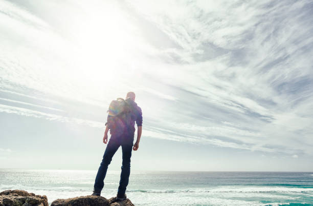 istock Man backlit in sunflare above the coast of South Cornwall. 645377816