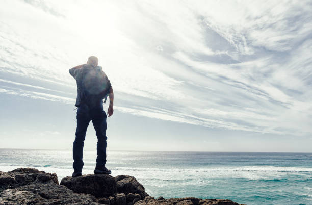 istock Man backlit in sunflare above the coast of South Cornwall. 645377824