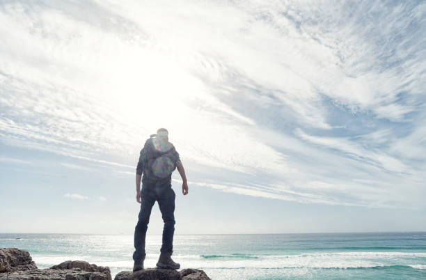 istock Man backlit in sunflare above the coast of South Cornwall. 645377834