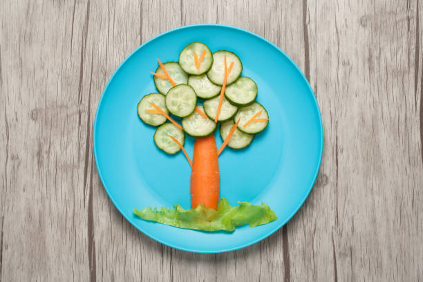 istock Tree made of cucumber and carrot on plate and table 645380820