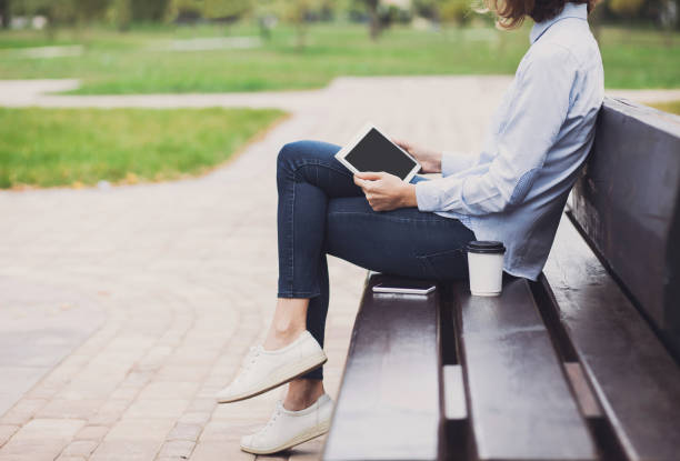 istock Young woman using digital tablet outdoors 645387496