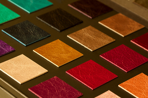 Colorful samples of leather on dark background, choice of texture and color