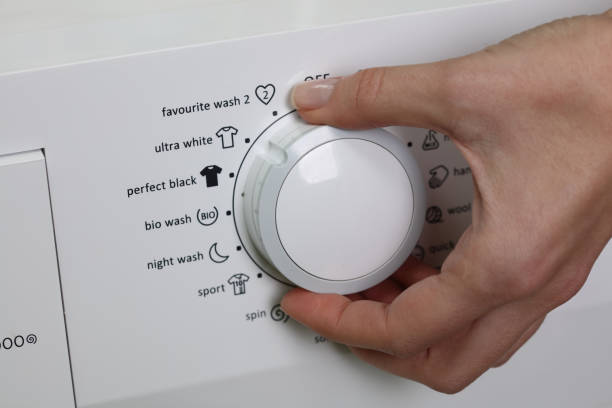 istock Close up on women hand and ultra white button on control panel of washing machine 645415322