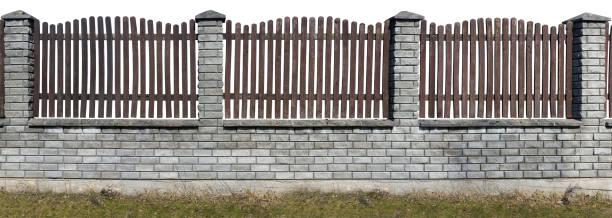 istock Several sections of a rustic style fence. Columns from a white beaten brick. A lattice from old brown pine boards. Isolated. Panoramic handmade object and collage 645416774