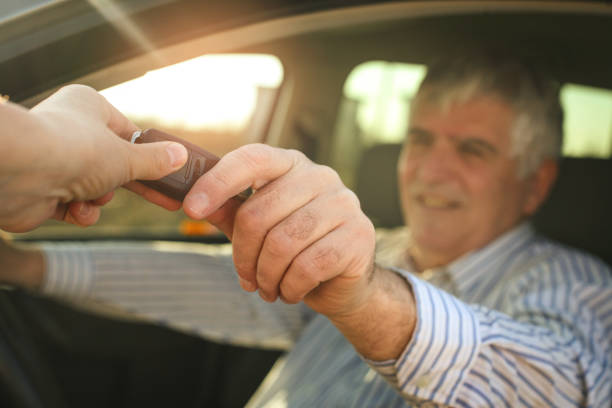 istock Senior man holding a car key. 645422340