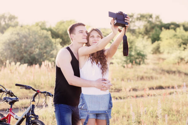 istock couple with bicycles taking selfie with digital camera 645438868