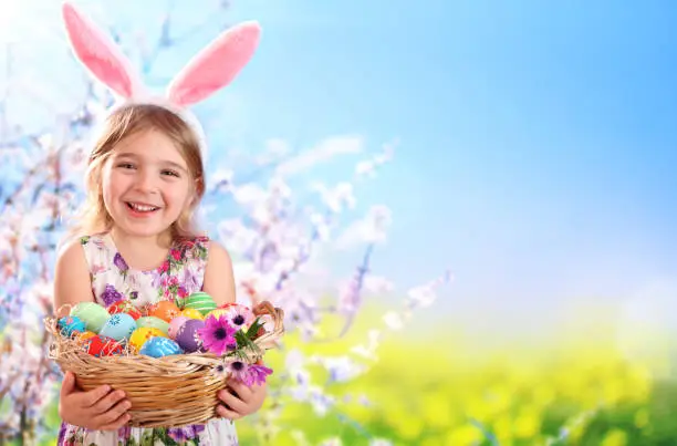 Little Girl Wearing Rabbit Ears Holding Basket Of Eggs