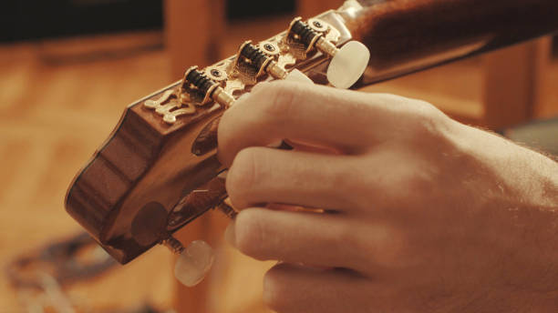 istock Guitarist's hands tuning guitar 645445104