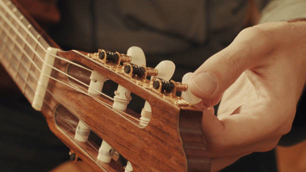 istock Guitarist's hands tuning guitar 645445218