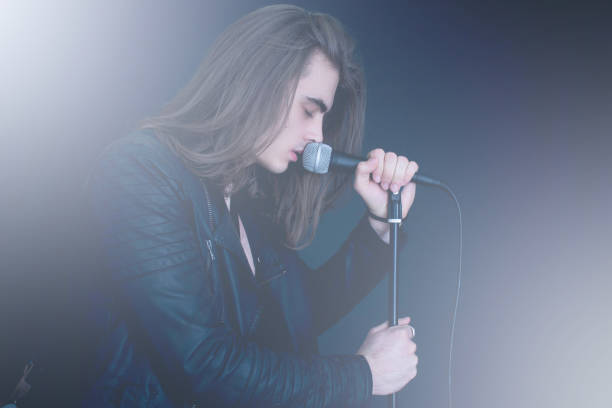 istock rocker with long hair singing in microphone 645462006
