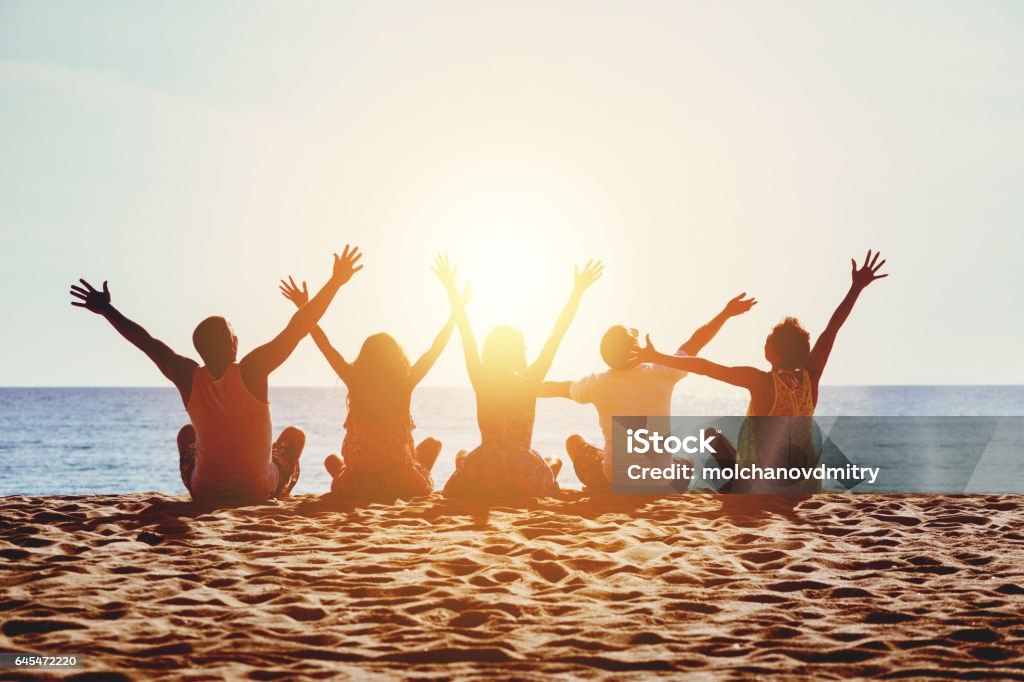 Gente feliz del grupo playa concepto puesta del sol de mar - Foto de stock de Playa libre de derechos