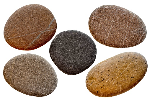 Group of pebble stones on sand creating de form of a foot in isolated white background.