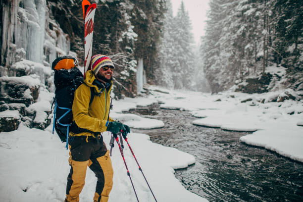 man with ski walking in the forest near the river stock photo