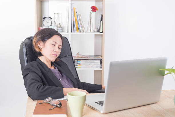 istock businesswoman sitting at table computer in office with sleep. 645488018