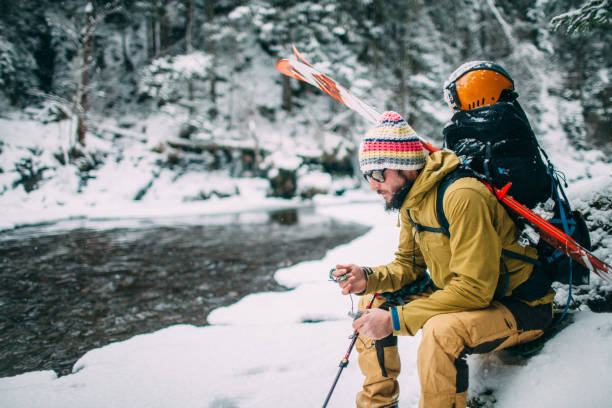 man with ski sitting in the snow forest stock photo