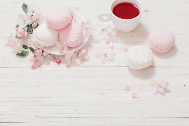 istock Red tea with flowers on white wooden background 645491590