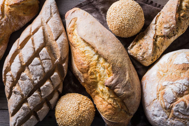 istock Several types of fresh bread lying on an old wooden table 645492292