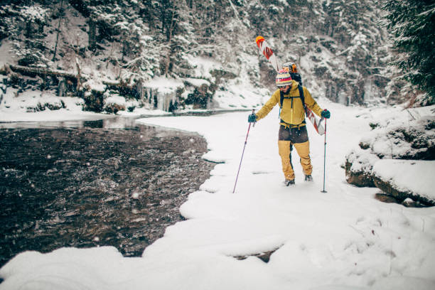 Young man with ski near the mountain river stock photo