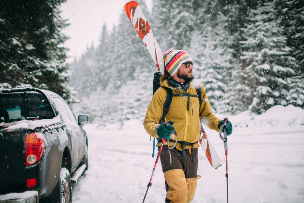 Young man with ski walking in the snow forest stock photo