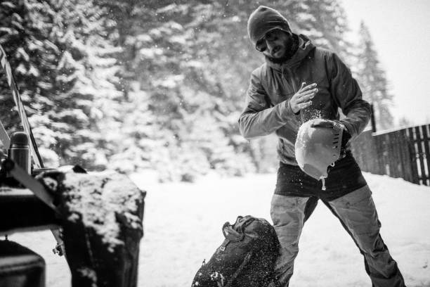 man in the snow forest shake off snow from helmet stock photo