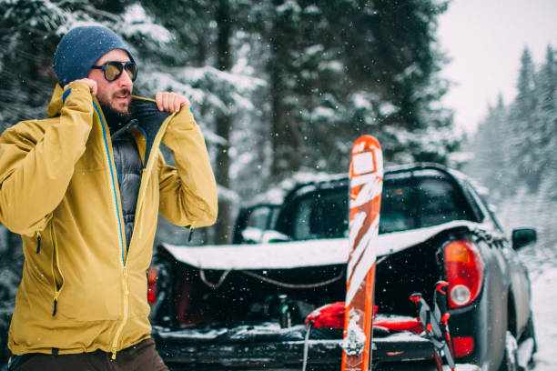 man with ski in the snow forest standing near car stock photo