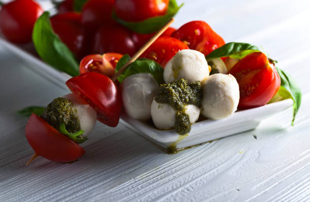 istock mozzarella with tomato , basil  and pesto sauce 645515666