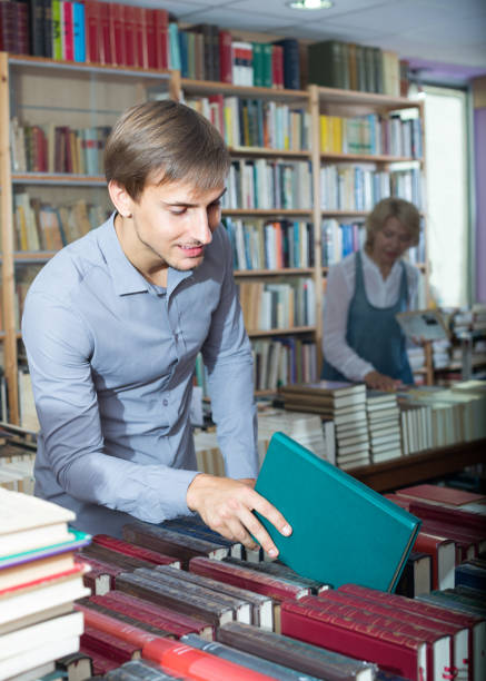 istock young man among bookshelves 645518586