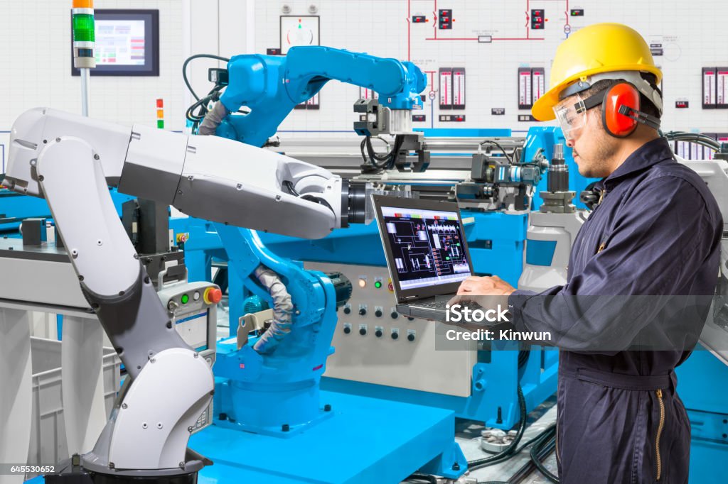 Ingeniero usando la computadora de mano robot automático de mantenimiento - Foto de stock de Manufacturar libre de derechos