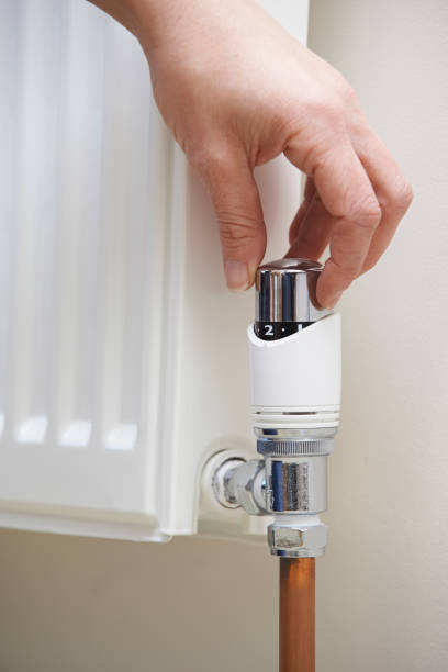istock Close Up Of Hand Adjusting Heating Thermostat 645534748