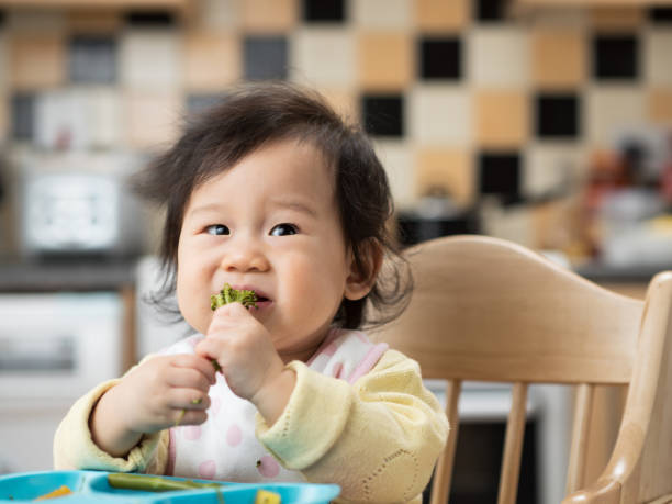 istock baby girl eating vegetable first time 645543042