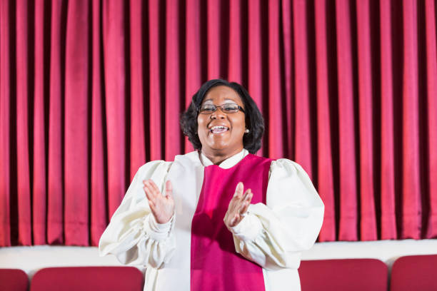 Black woman singing in church choir A mature black woman singing in a church choir. She is singing and clapping. black female gospel singers stock pictures, royalty-free photos & images