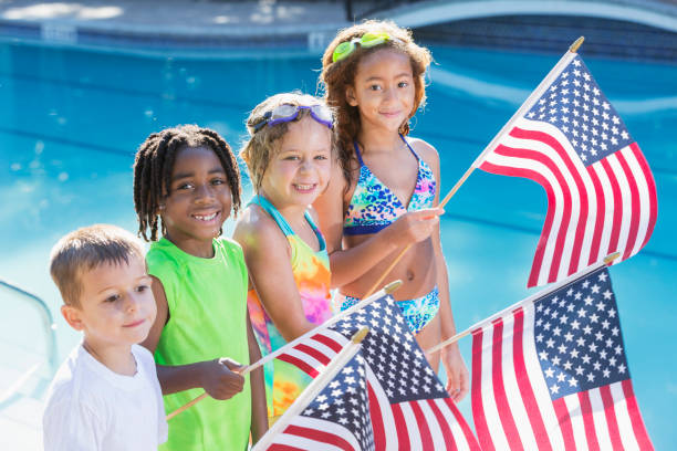 wieloetniczne dzieci na basenie trzymające amerykańskie flagi - patriotism child american culture flag zdjęcia i obrazy z banku zdjęć