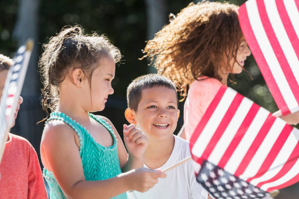 istock Multi-ethnic children waving American flags 645600598