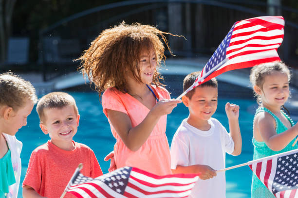 wieloetniczne dzieci na basenie trzymające amerykańskie flagi - patriotism child american culture flag zdjęcia i obrazy z banku zdjęć