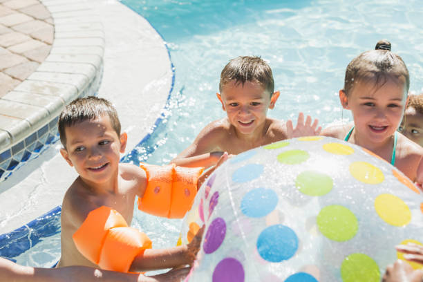 istock Multi-ethnic children with giant beach ball in pool 645600690