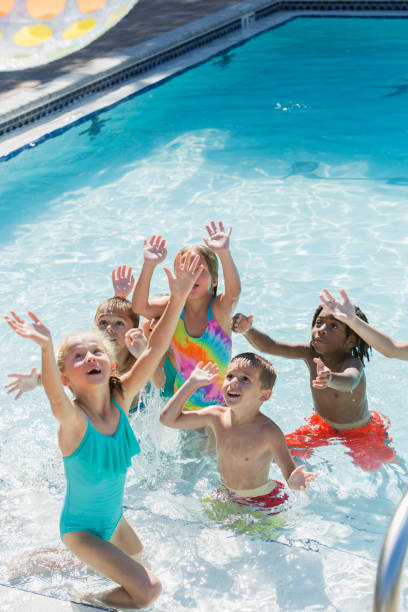 istock Multi-ethnic group of children playing in swimming pool 645600696