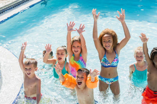 istock Multi-ethnic group of children playing in swimming pool 645600756