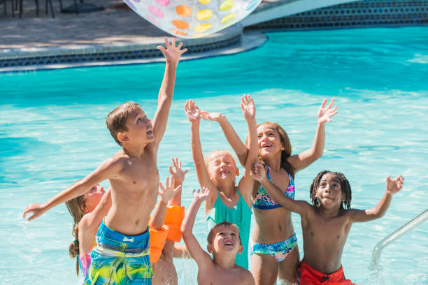 groupe d’enfants dans la piscine pour atteindre pour la boule - beach ball swimming pool ball child photos et images de collection