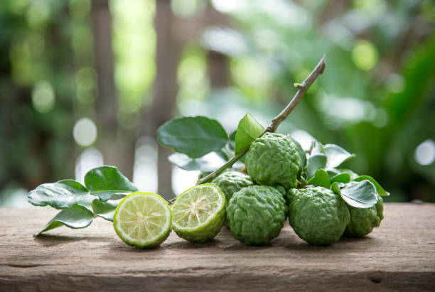 Makrut lime Kaffir lime with leaves on wooden background. kaffir stock pictures, royalty-free photos & images
