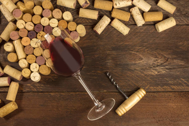 Glass of red wine, corkscrew and corks with copyspace