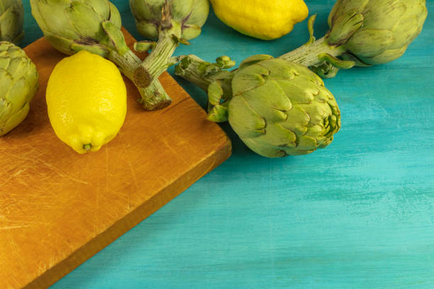 Artichokes and lemons on vibrant turquoise texture with a place for text