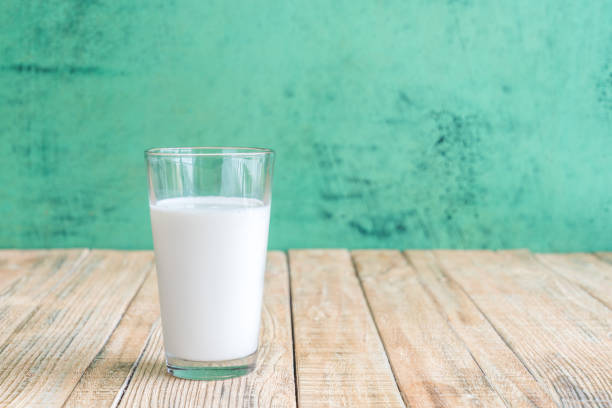 istock milk on a wooden table on Green background 645618514