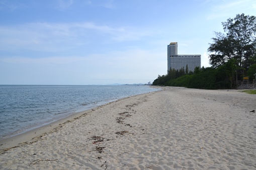 Long beach at Cha-Am, a resort town along the Gulf of Thailand near Hua Hin, and known among Thai families for being a weekend destination within driving distance from the capital. It lies 173 km south of Bangkok. In the bacgkround, people walking on the shore.
