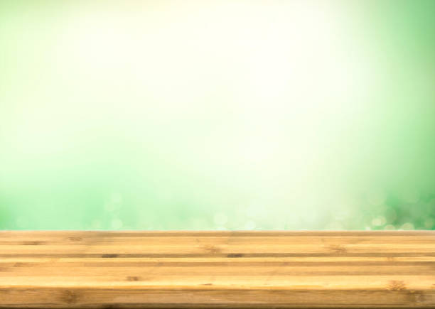 istock wooden table top with abstract blur green background 645625316