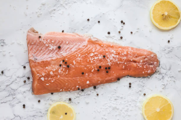 gravlax de salmão em conserva com pimenta e limão sobre fundo de mármore - gravlax - fotografias e filmes do acervo