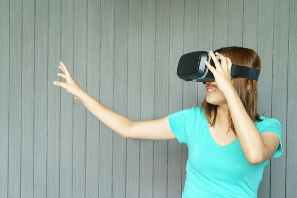 istock Young woman in virtual reality glasses touching something 645629030