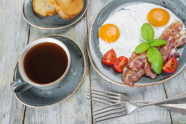 istock Fried eggs,  bacon, tomato, toast and a cup of coffee 645631466