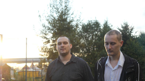 istock Young men have a serious talk while walking in the city during beautiful sunset with lense flare effects 645631982